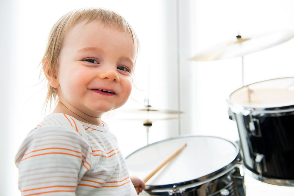 Smiling Boy Playing the Drums for Therapeutic Relief