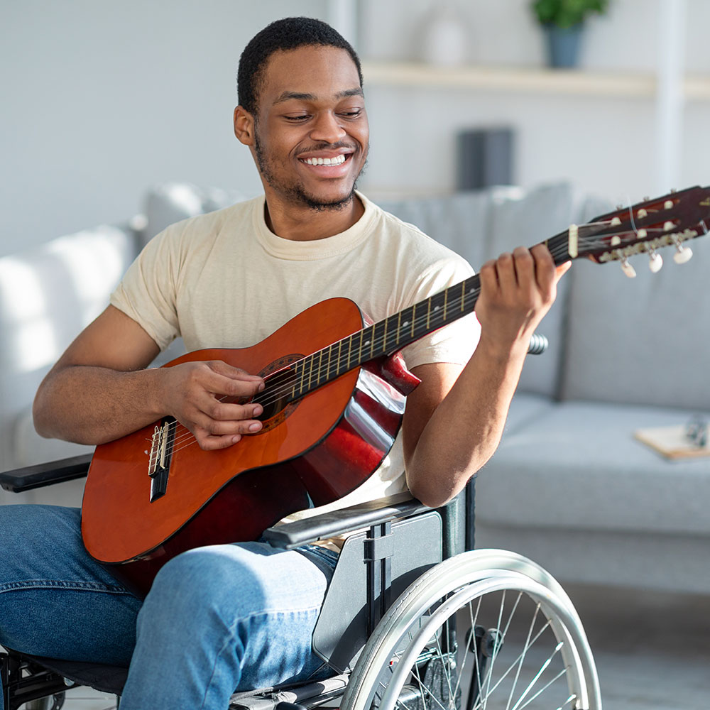 Handicapped Person on Wheelchair Playing a Guitar